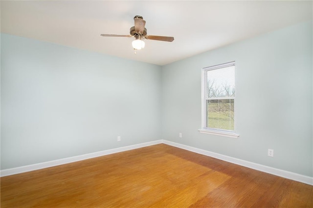 spare room with light wood-style floors, baseboards, and ceiling fan