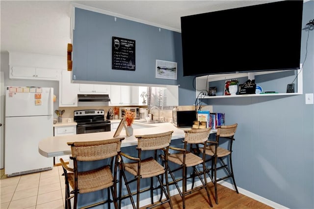 5023 Freeway Ln, Mobile, AL 36619 - kitchen with white refrigerator, a breakfast bar, white cabinets, and electric range