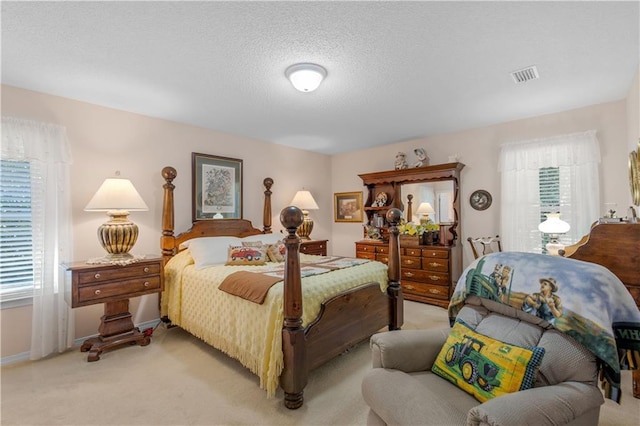 bedroom featuring light carpet, multiple windows, and a textured ceiling