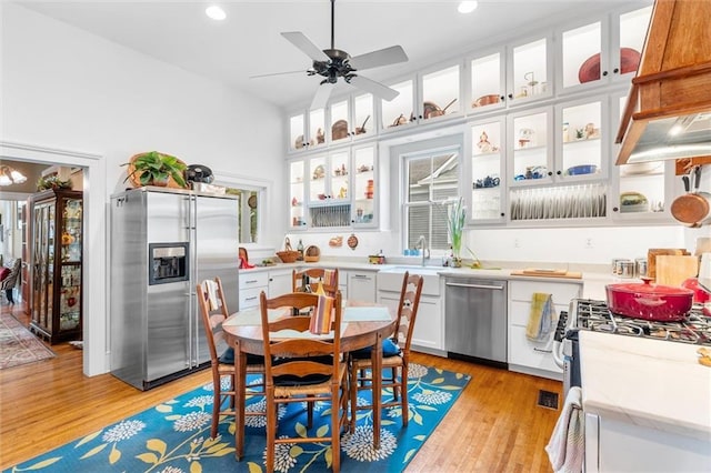 kitchen with sink, light hardwood / wood-style floors, white cabinetry, and stainless steel appliances