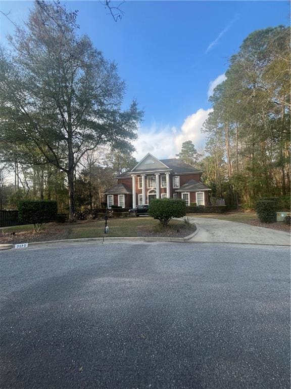 greek revival house featuring concrete driveway