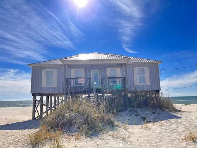 rear view of house featuring a water view, a view of the beach, and a carport