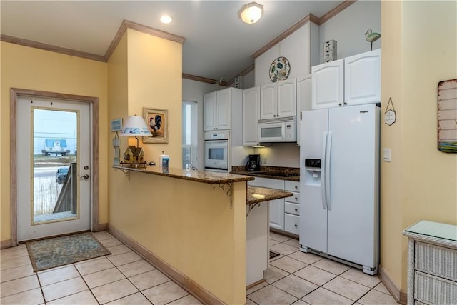 kitchen featuring white appliances, white cabinets, dark stone countertops, ornamental molding, and kitchen peninsula