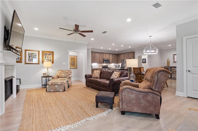 living room featuring ceiling fan with notable chandelier and light hardwood / wood-style floors