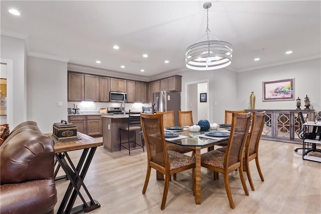 dining room featuring ornamental molding, a notable chandelier, and light hardwood / wood-style floors