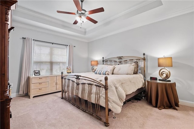 bedroom featuring light carpet, a tray ceiling, ceiling fan, and crown molding