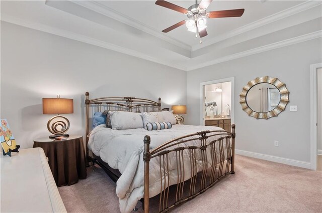 carpeted bedroom with ceiling fan, a raised ceiling, connected bathroom, and ornamental molding