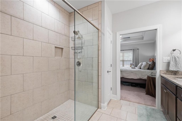 bathroom with tile patterned floors, vanity, and tiled shower