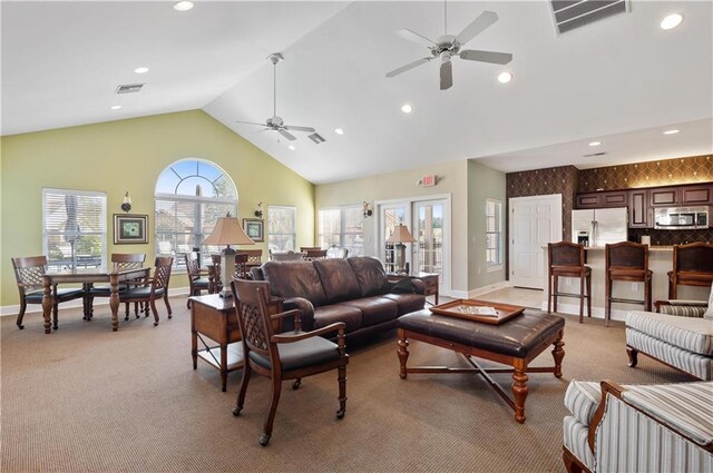 carpeted living room featuring ceiling fan and high vaulted ceiling