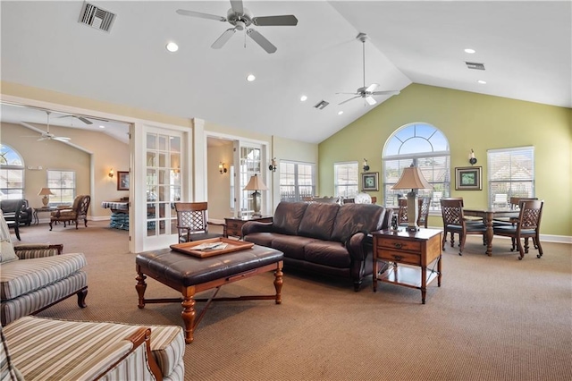 carpeted living room with high vaulted ceiling, ceiling fan, and a healthy amount of sunlight