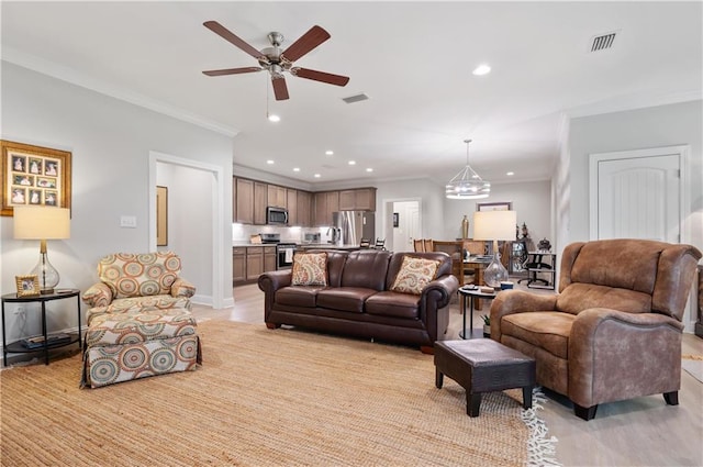 living room with ceiling fan with notable chandelier and crown molding