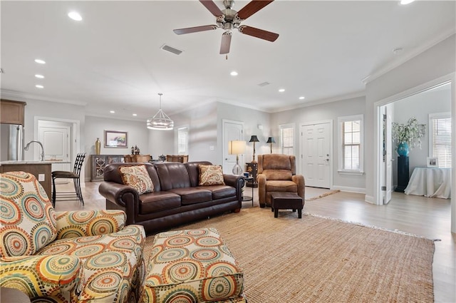 living room featuring crown molding, ceiling fan, and light hardwood / wood-style flooring