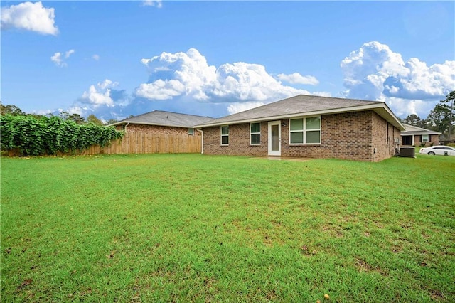 rear view of house featuring a yard