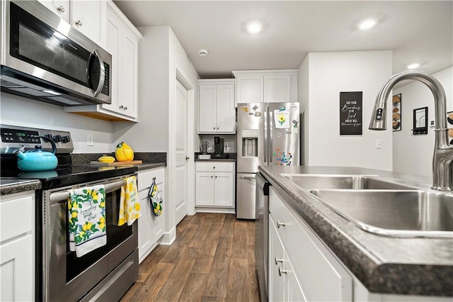 kitchen featuring appliances with stainless steel finishes, sink, white cabinets, and dark hardwood / wood-style floors