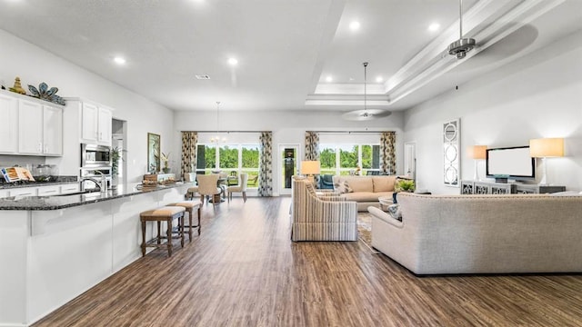 2260 Nadine Ln, Mobile, AL 36695 - living room featuring dark wood-style floors, recessed lighting, a ceiling fan, and a raised ceiling