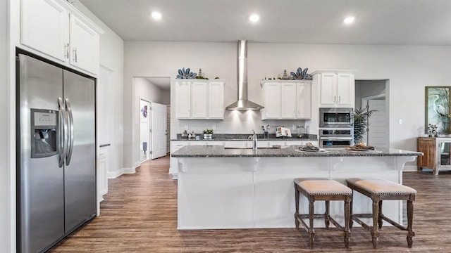2260 Nadine Ln, Mobile, AL 36695 - kitchen featuring appliances with stainless steel finishes, wall chimney range hood, an island with sink, a sink, and white cabinets