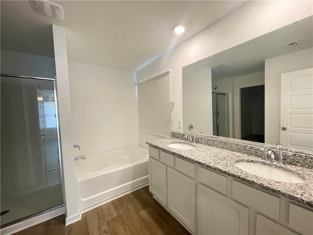 bathroom with vanity, wood-type flooring, and plus walk in shower