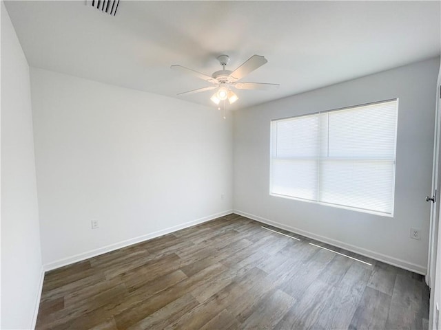 unfurnished room with dark hardwood / wood-style floors and ceiling fan