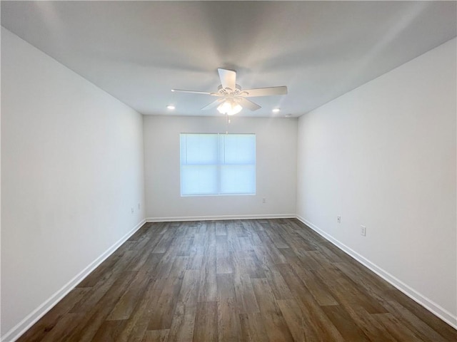 empty room with ceiling fan and dark hardwood / wood-style flooring