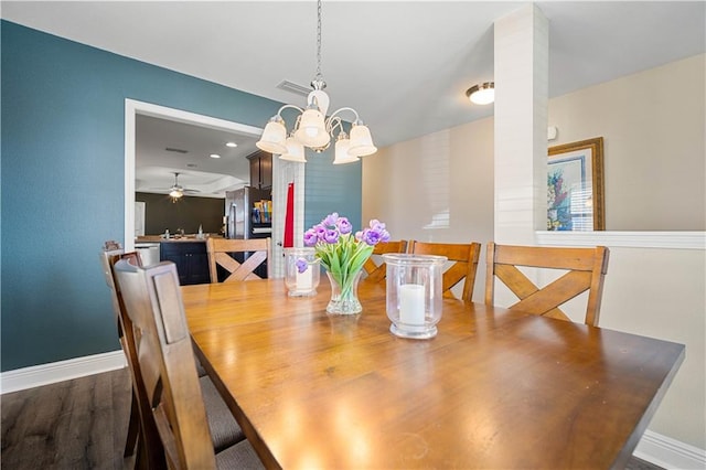 dining room featuring dark wood-type flooring and ceiling fan with notable chandelier