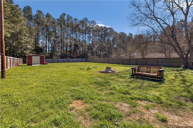 view of yard featuring a shed, an outdoor structure, and a fenced backyard