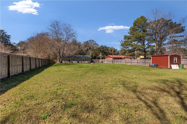 view of yard with a fenced backyard, an outdoor structure, and a shed