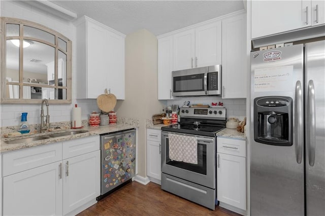 kitchen with stainless steel appliances, a sink, and white cabinetry