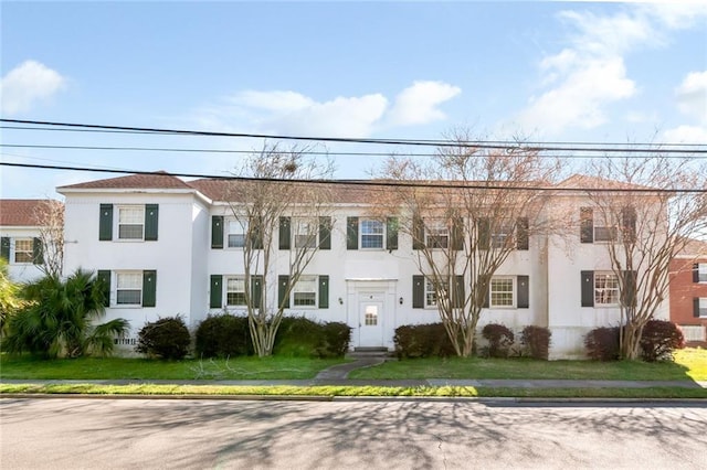 view of front facade featuring a front yard and stucco siding