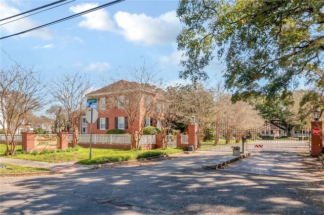 exterior space with driveway, fence, and a gate