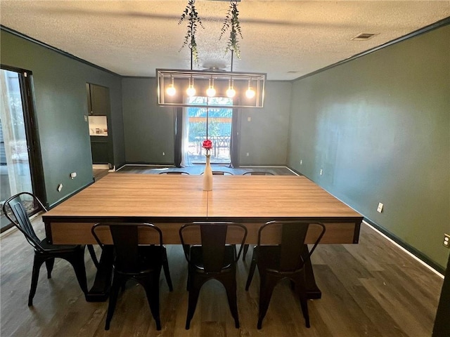 dining space with hardwood / wood-style flooring and a textured ceiling