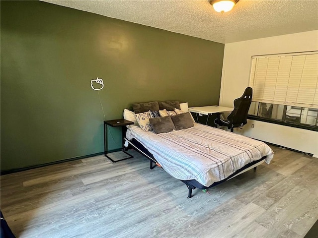 bedroom featuring hardwood / wood-style flooring and a textured ceiling