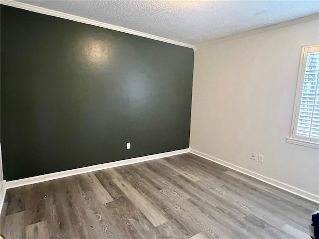 spare room featuring ornamental molding, dark hardwood / wood-style floors, and a textured ceiling