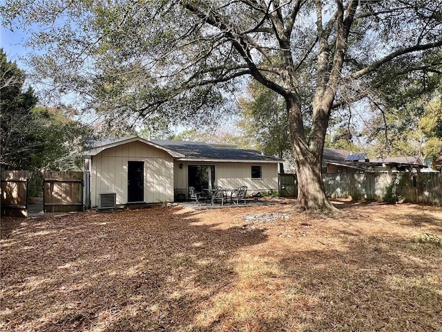 rear view of property with central AC