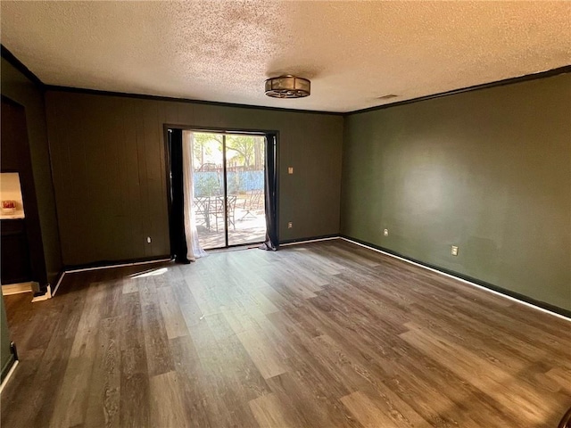 empty room featuring crown molding, wood-type flooring, and a textured ceiling