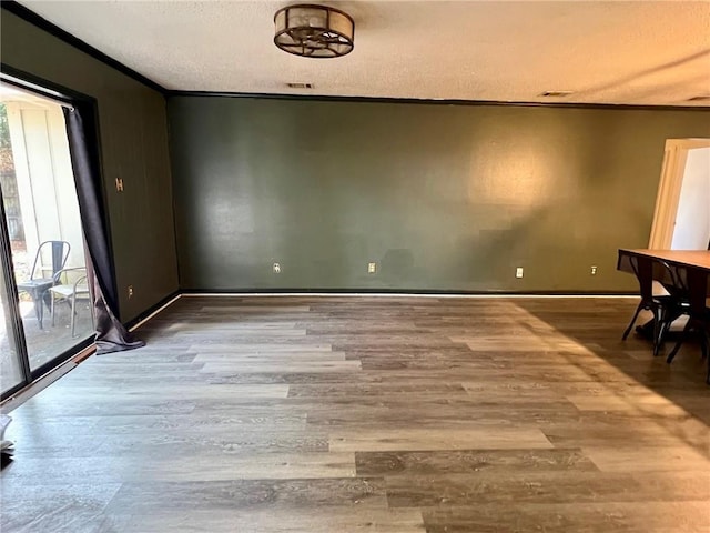 unfurnished dining area with ornamental molding, wood-type flooring, and a healthy amount of sunlight