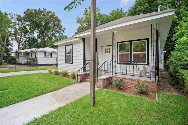 view of front facade featuring concrete driveway, a front lawn, and a porch