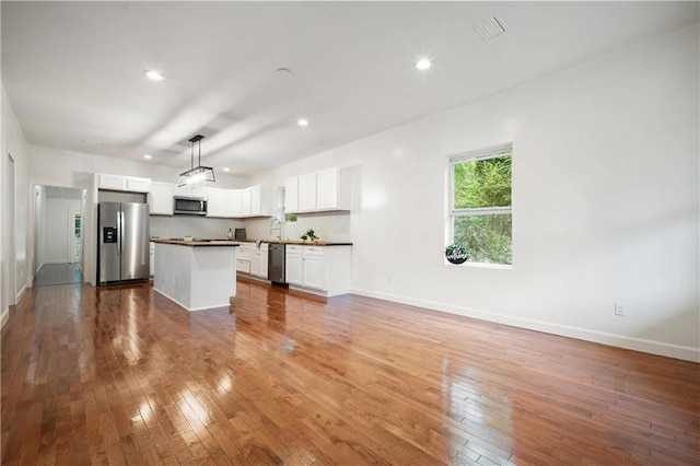 4 Straight St, Mobile, AL 36604 - kitchen with appliances with stainless steel finishes, white cabinetry, backsplash, and hardwood / wood-style flooring