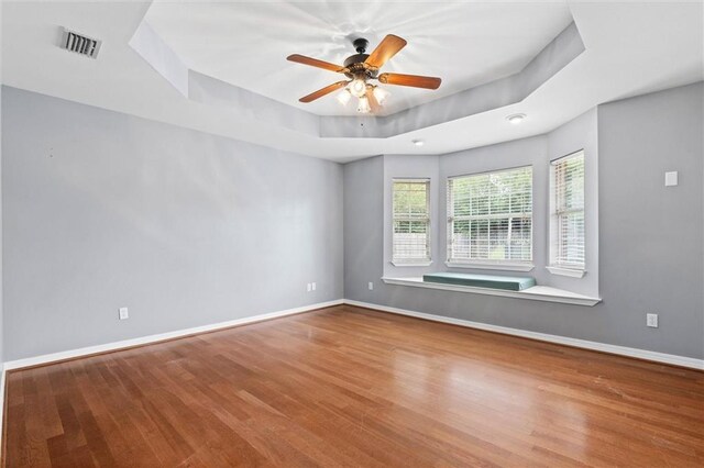 405 Baker Rd, Satsuma, AL 36572 - spare room featuring wood finished floors, a tray ceiling, baseboards, and ceiling fan