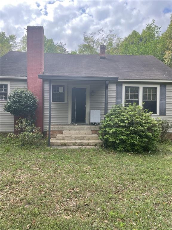 2065 Magnolia Ln, Mobile, AL 36605 - rear view of house with a chimney and a lawn