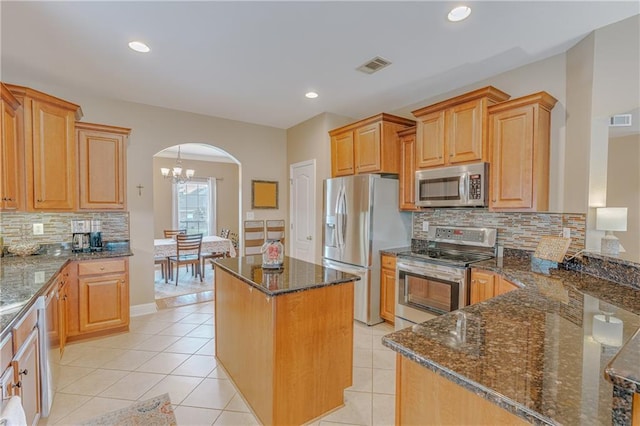 10808 Legacy Ln, Mobile, AL 36608 - kitchen with appliances with stainless steel finishes, arched walkways, dark stone counters, decorative backsplash, and a chandelier