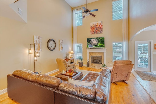 10808 Legacy Ln, Mobile, AL 36608 - living room with a towering ceiling, arched walkways, a fireplace, a ceiling fan, and wood finished floors