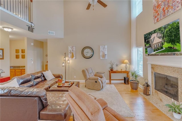 10808 Legacy Ln, Mobile, AL 36608 - living area featuring a towering ceiling, plenty of natural light, wood finished floors, ceiling fan, and a fireplace with flush hearth