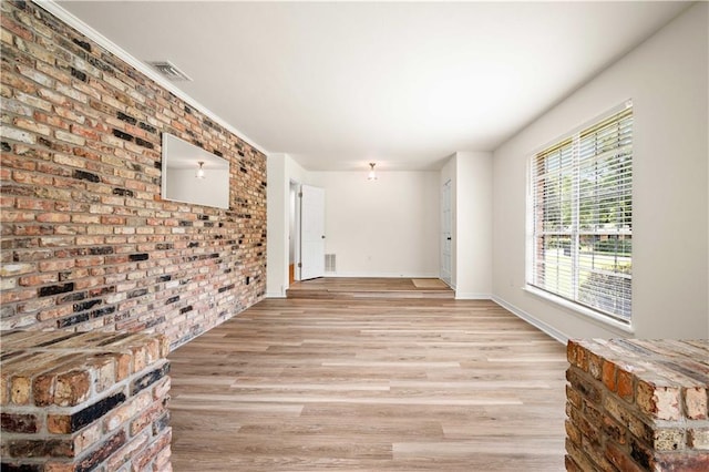 interior space featuring light hardwood / wood-style flooring and brick wall