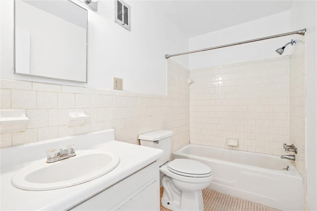 full bathroom featuring tile walls, vanity, tiled shower / bath combo, toilet, and tile patterned floors