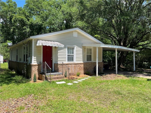 124 Clark Ave, Saraland, AL 36571 - bungalow-style home with a front lawn, brick siding, fence, and a carport