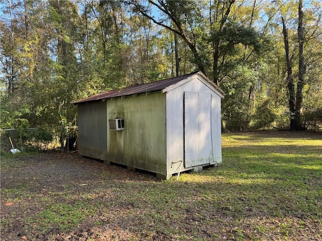 view of outbuilding with a lawn and a wall unit AC