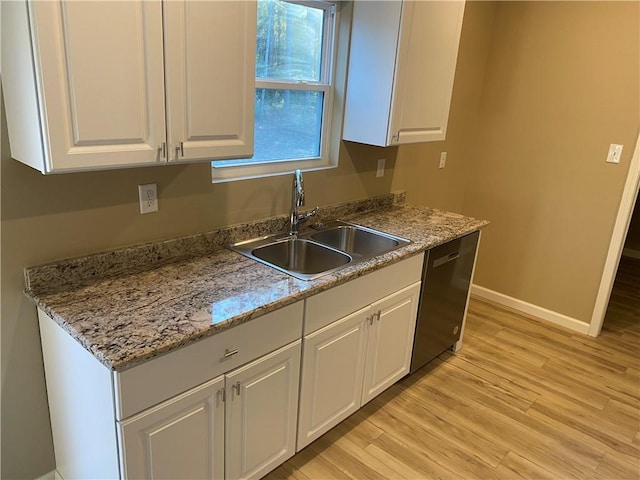 kitchen featuring white cabinetry, sink, dishwasher, light stone countertops, and light hardwood / wood-style flooring