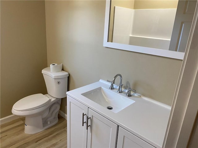 bathroom with vanity, wood-type flooring, and toilet