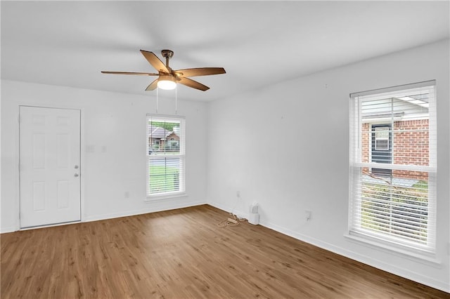 unfurnished room with wood finished floors, ceiling fan, and baseboards