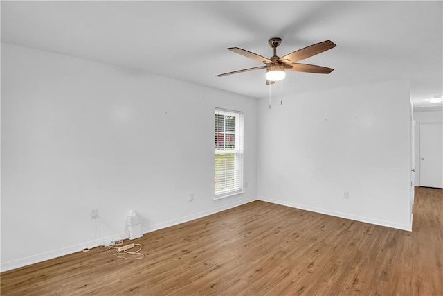 unfurnished room featuring baseboards, wood finished floors, and a ceiling fan